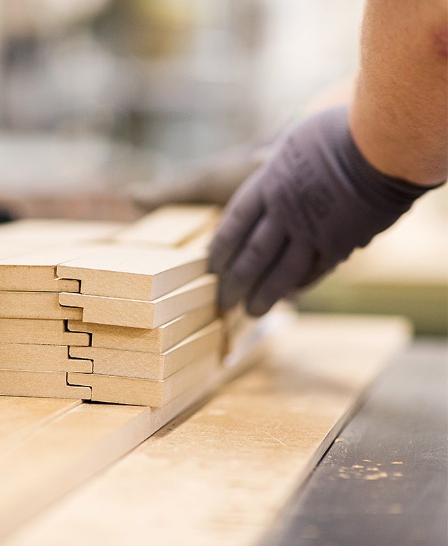 Hand mit Handschuh schiebt Bretter zusammen